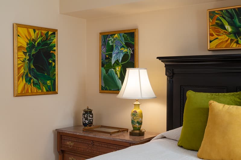 bed with beside table with lamp and vase of flowers