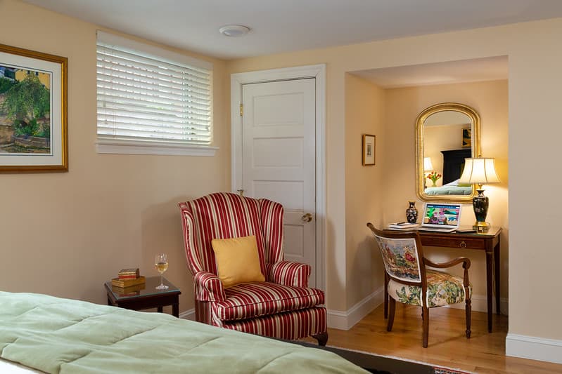 sitting area with writing desk and vase of flowers