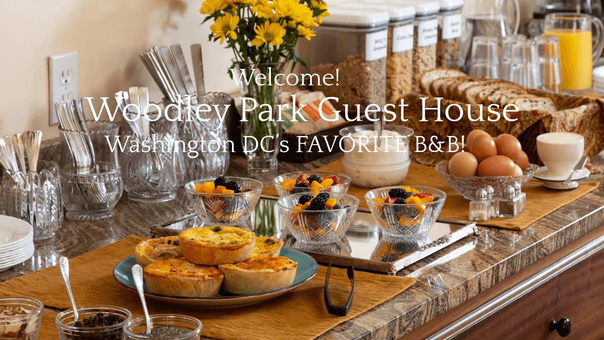 A beautifully arranged breakfast spread at Woodley Park Guest House featuring pastries, fruits, and drinks.